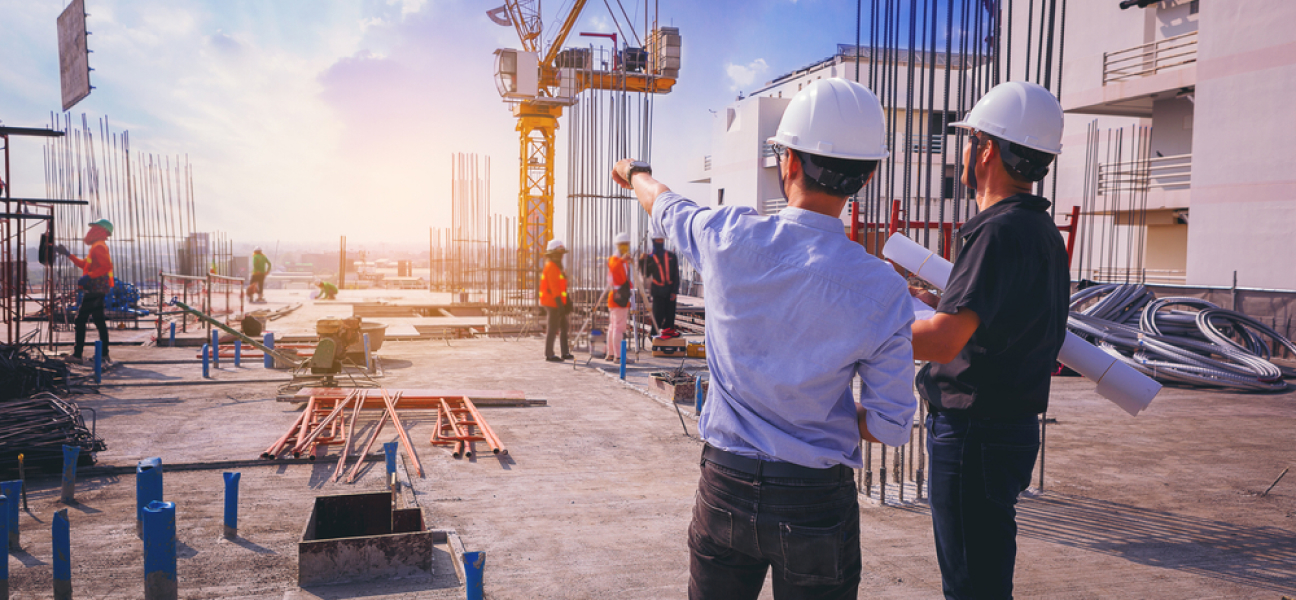 Industrial project managers on site suitable for heavy-duty temporary warehouse structures or shelters.